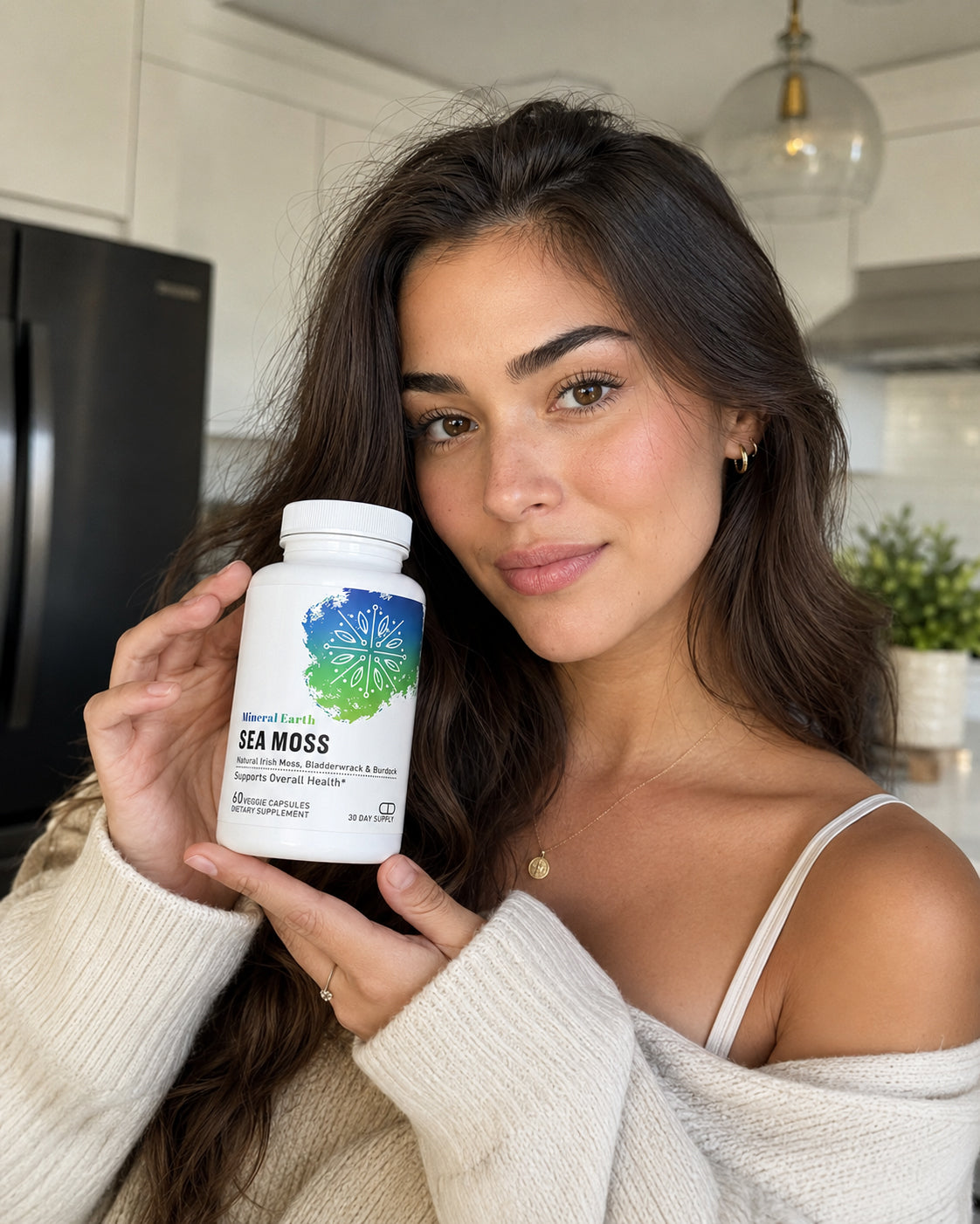 Woman holding Mineral Earth Sea Moss supplement bottle